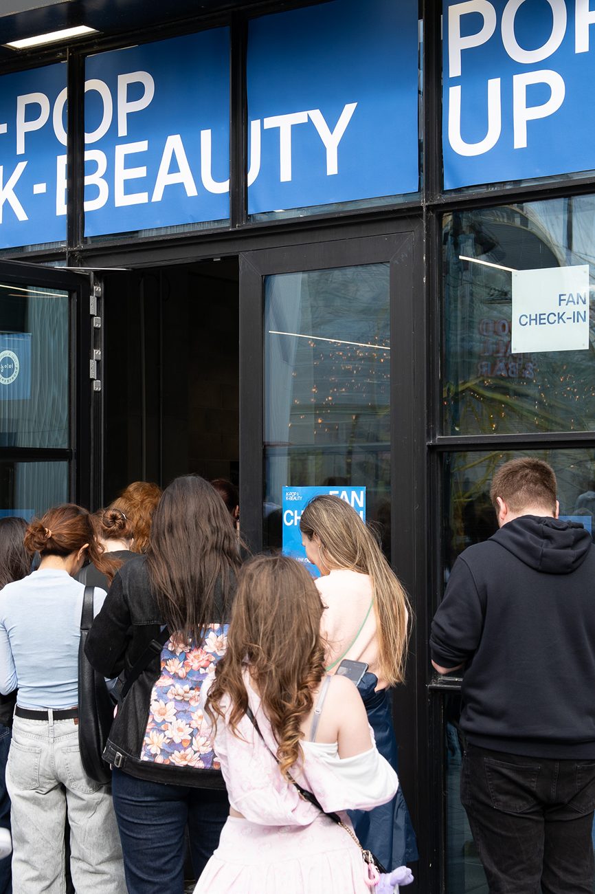 Visitors queueing at the fan check-in desk inside the K-POP K-BEAUTY pop-up entrance.